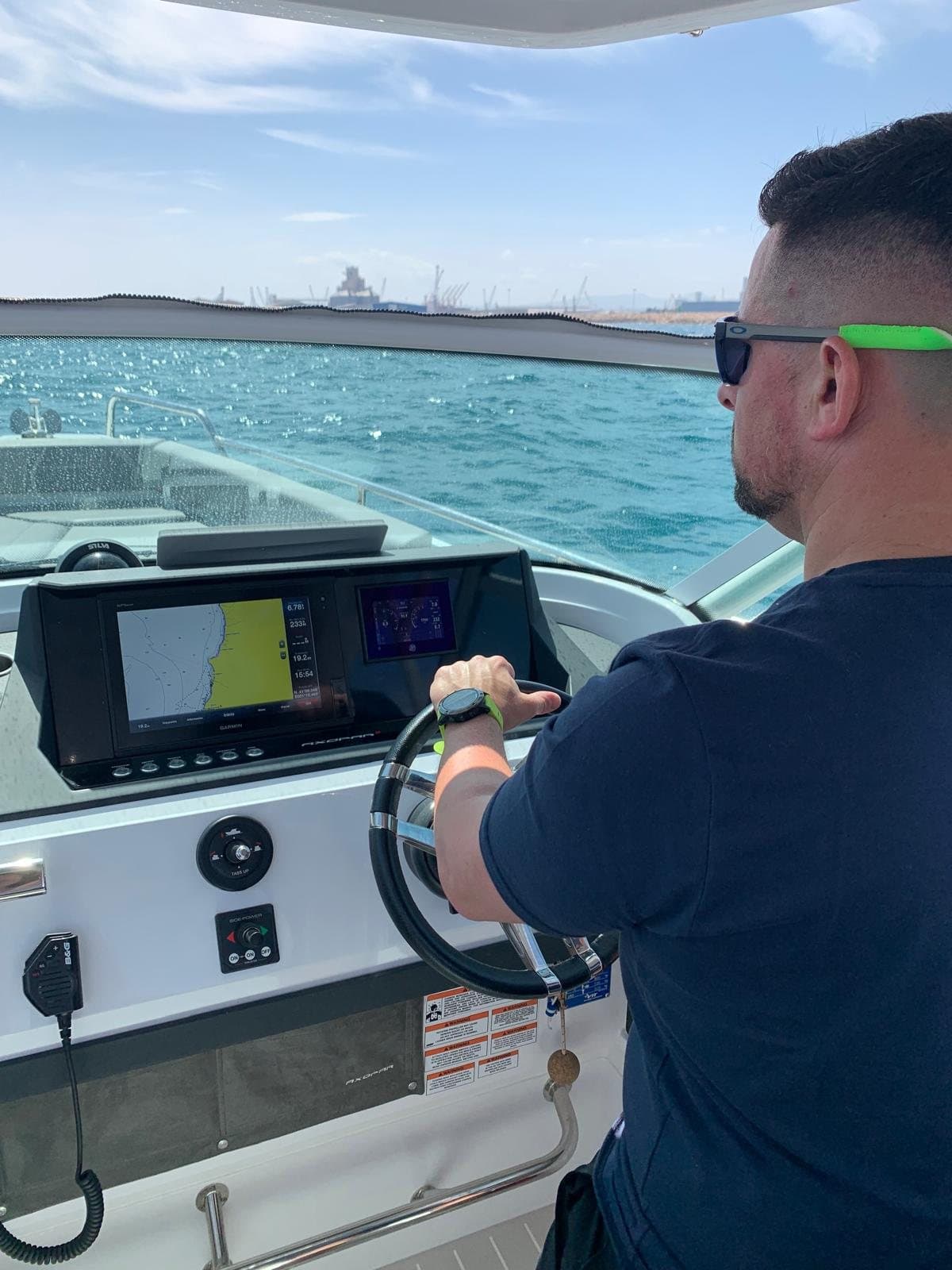 Sergio pilotando una lancha con la pantalla del plotter delante